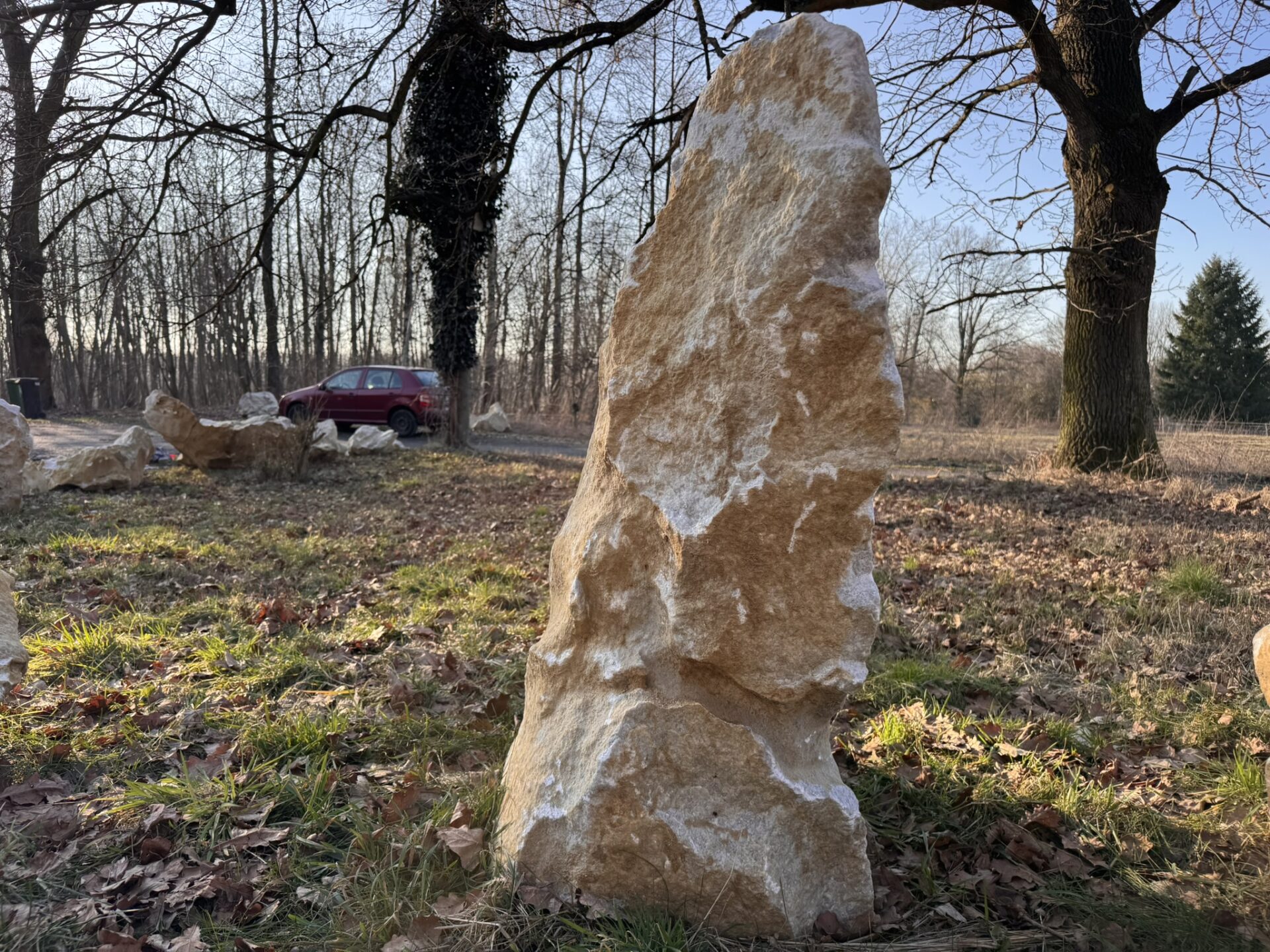 Vertikální mramorový solitér K8 z přírodního mramoru v pískově-zlatém odstínu s bílou kresbou.